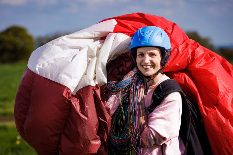 Student carrying a paraglider after training