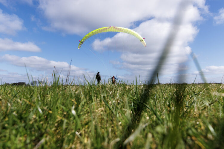 Paraglider low over grass